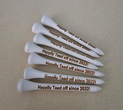 White golf tees with 'Happily Teed off since 2022!' 